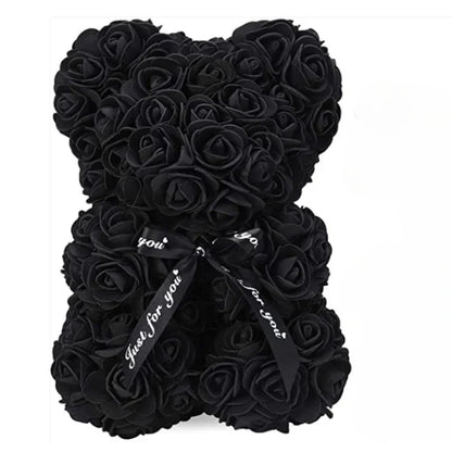 A black teddy bear made out of eternal flowers.