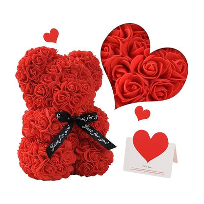 A red teddy bear made out of eternal flowers. With a red heart on the right hand side and a card under the heart.